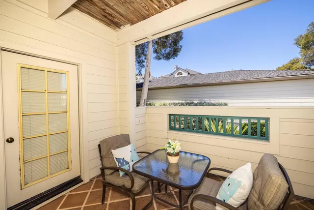 a front view of a house with a yard and potted plants