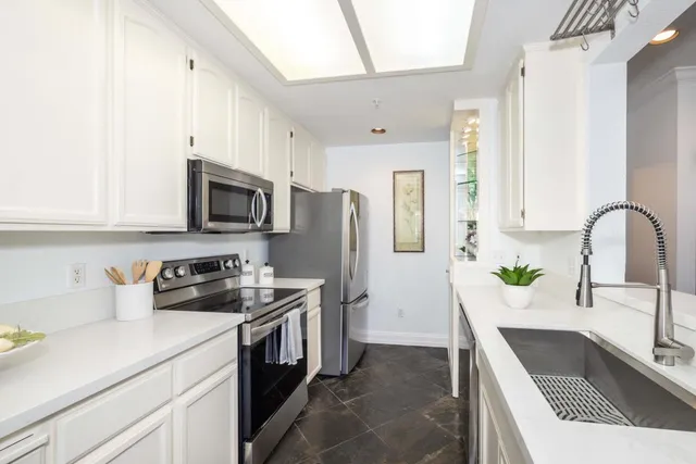 a kitchen with a sink a stove and cabinets