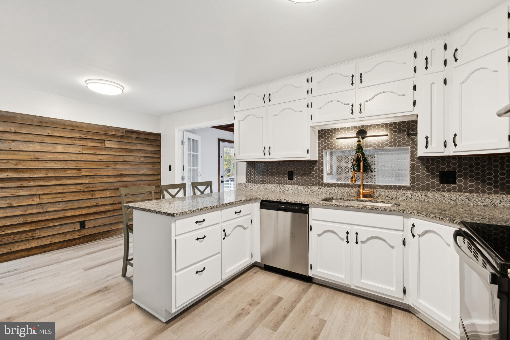 24530 Hollywood Road Hollywood, MD 20636 - Photo 13 of 40 a kitchen with granite countertop a sink a stove and cabinets