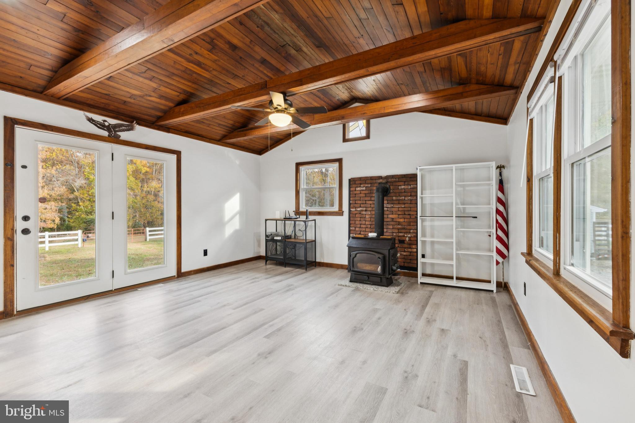 24530 Hollywood Road Hollywood, MD 20636 - Photo 16 of 40 a view of an empty room with wooden floor a ceiling fan and windows