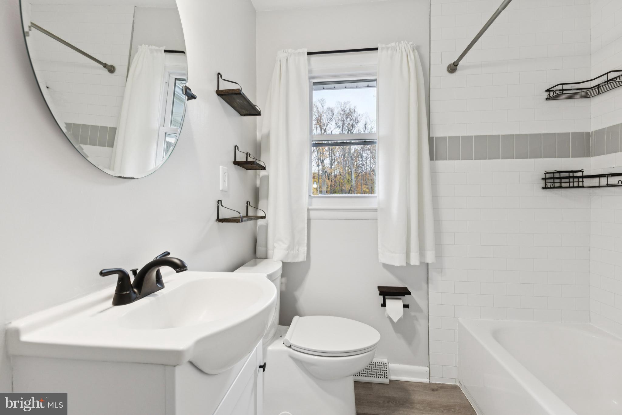 24530 Hollywood Road Hollywood, MD 20636 - Photo 18 of 40 a bathroom with a sink a toilet and a mirror