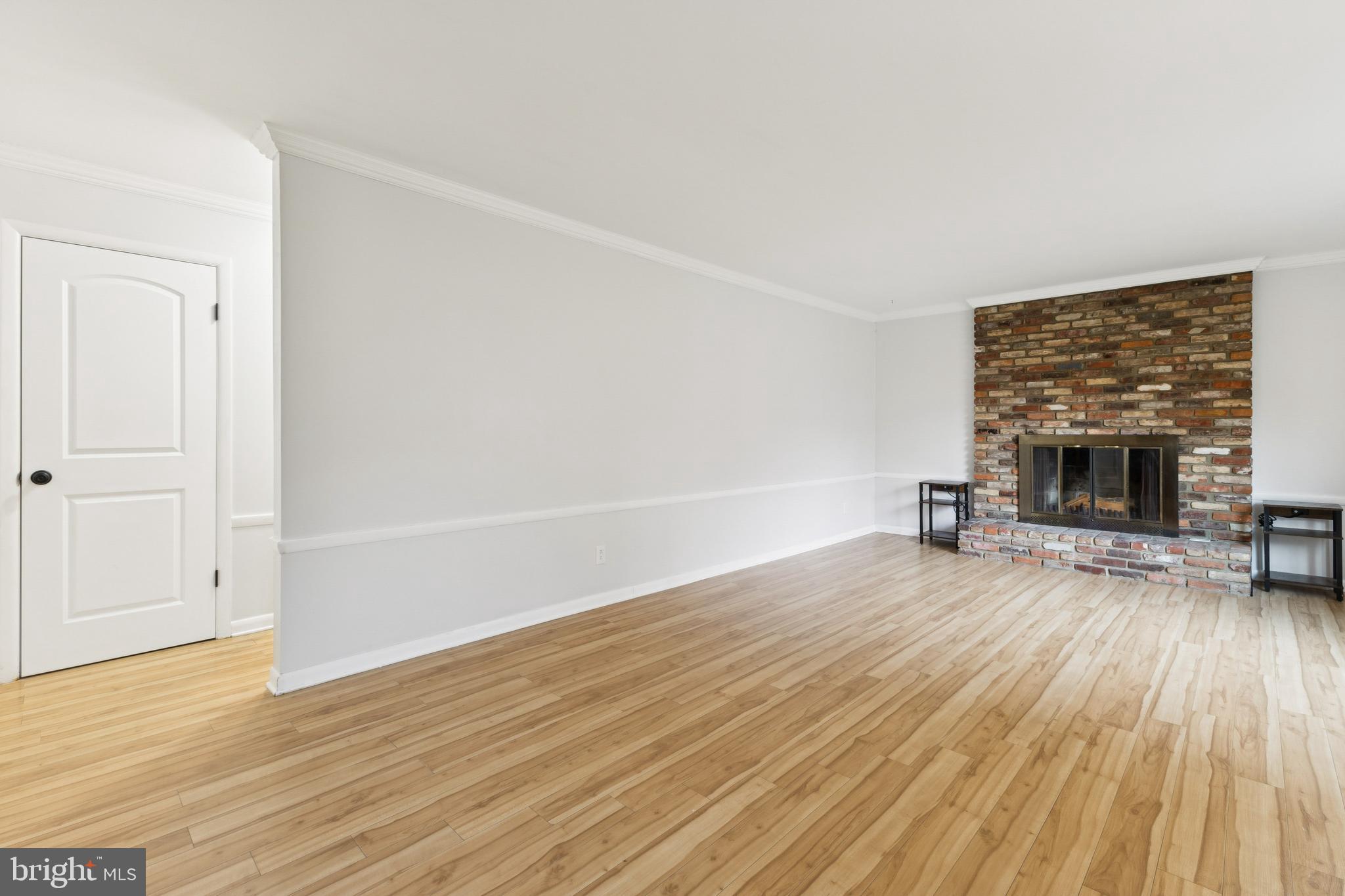 24530 Hollywood Road Hollywood, MD 20636 - Photo 6 of 40 an empty room with wooden floor fireplace and windows