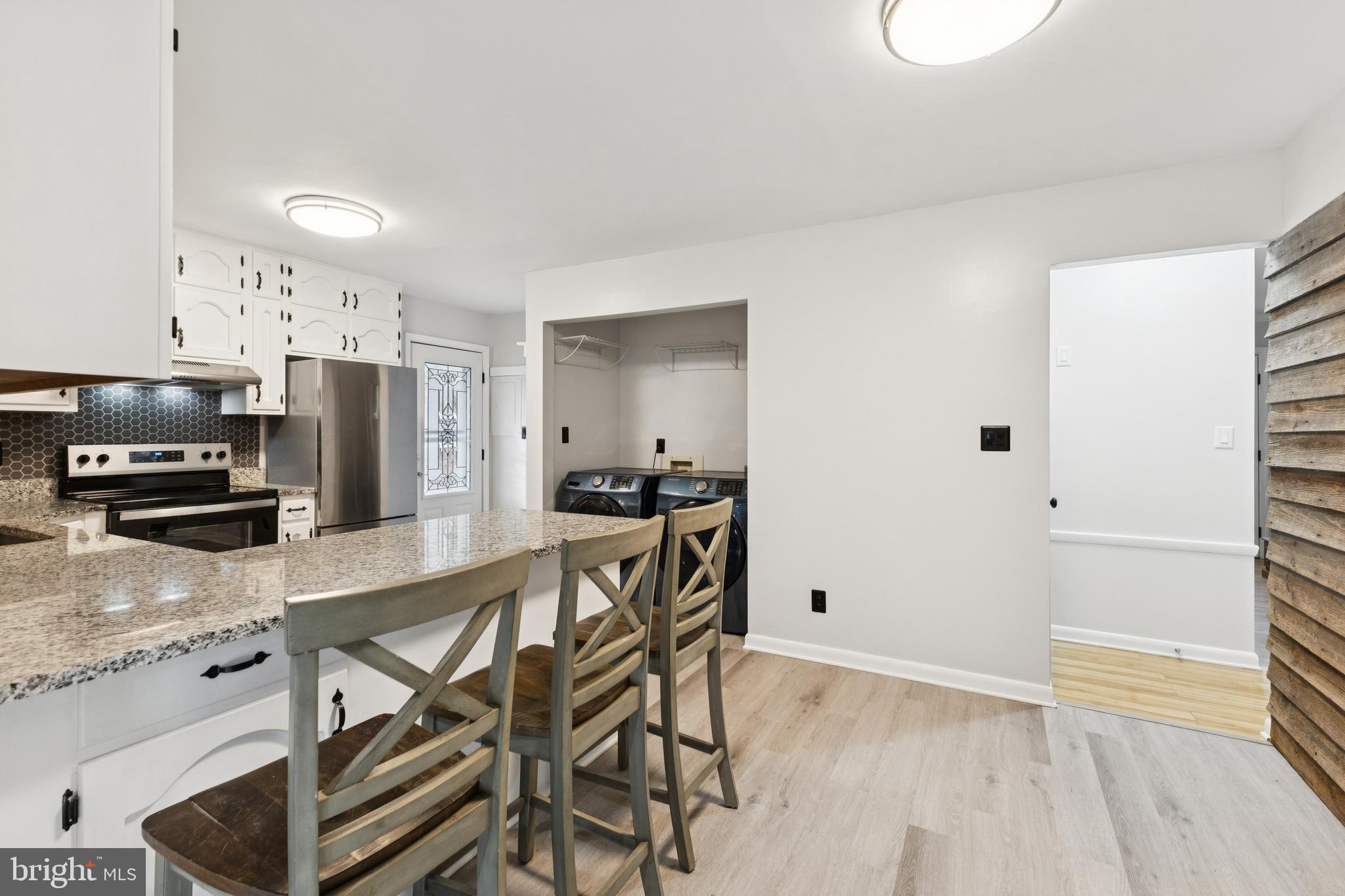 24530 Hollywood Road Hollywood, MD 20636 - Photo 10 of 40 a kitchen with granite countertop a stove a sink and a refrigerator