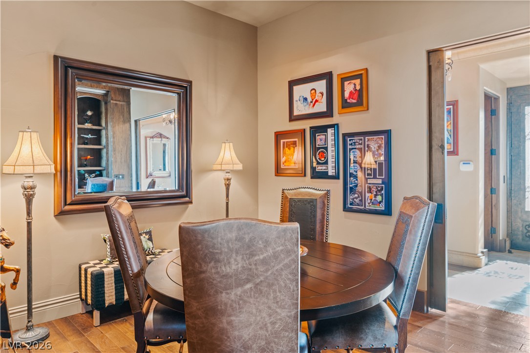 1123 Christian Road Henderson, NV 89002 - Photo 37 of 94 A well-lit dining area featuring rich hardwood flooring and a stylish, framed mirror.