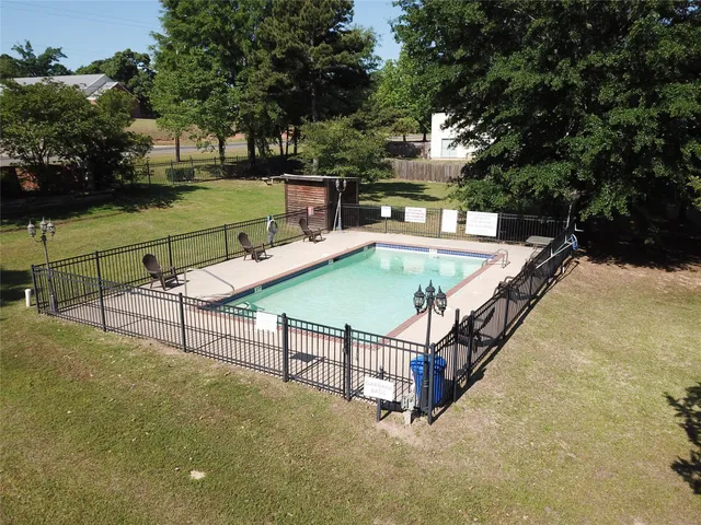 a view of a swimming pool with a patio and a backyard