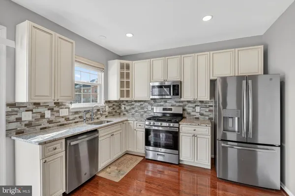 a kitchen with stainless steel appliances a stove sink and refrigerator