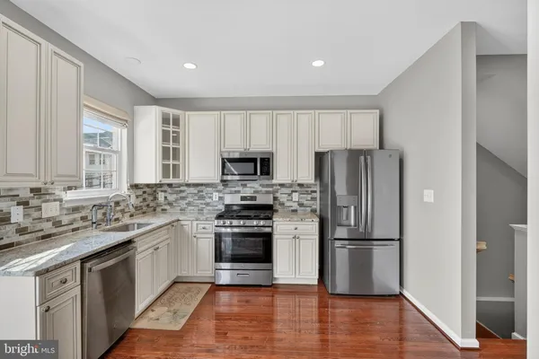 a kitchen with a refrigerator sink and cabinets