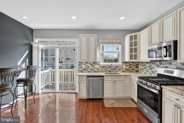 a kitchen with stainless steel appliances granite countertop a stove and cabinets