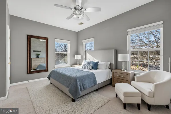 a spacious bedroom with a bed and glass walk in closet