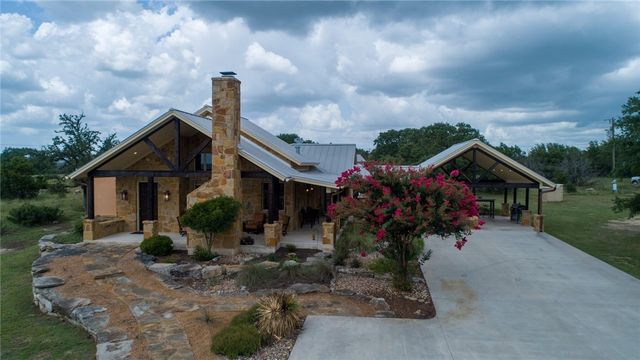 633 Trails End Road Johnson City, TX 78636 - Photo 25 of 29 Exquisite stone architecture highlights the exterior of this custom home with a metal roof.