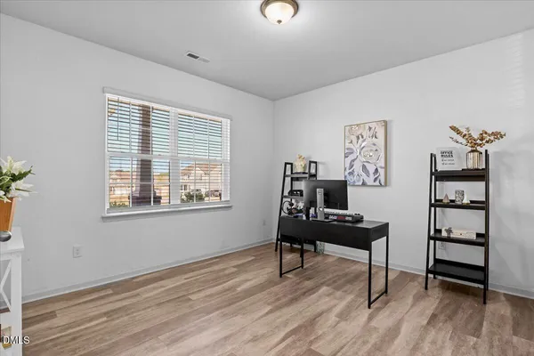 a view of a workspace with furniture and a window