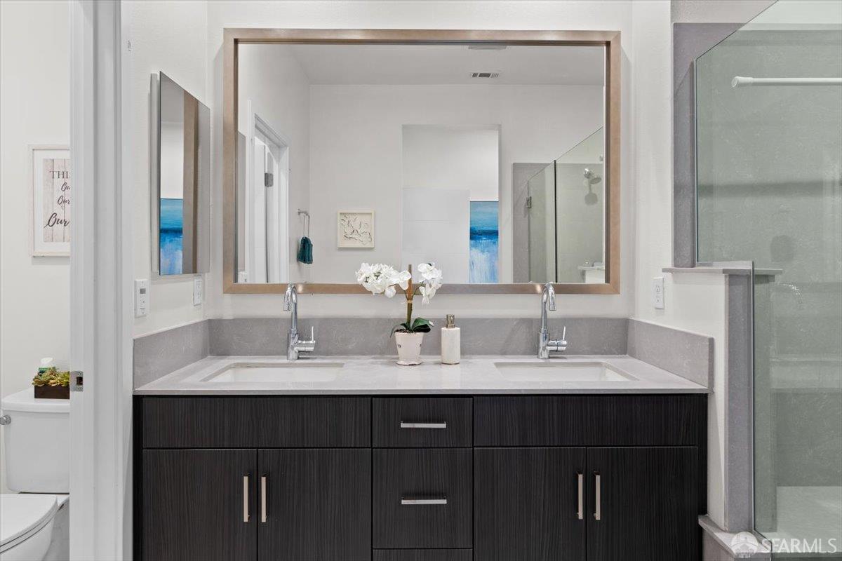 1807 16th Street Oakland, CA 94607 - Photo 21 of 45 a bathroom with a double vanity sink and a mirror