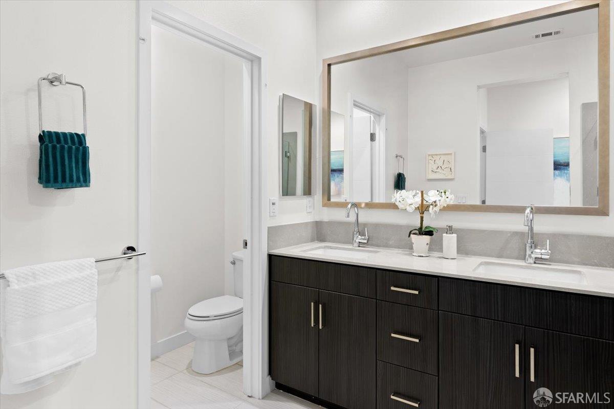 1807 16th Street Oakland, CA 94607 - Photo 23 of 45 a bathroom with a double vanity sink toilet and mirror