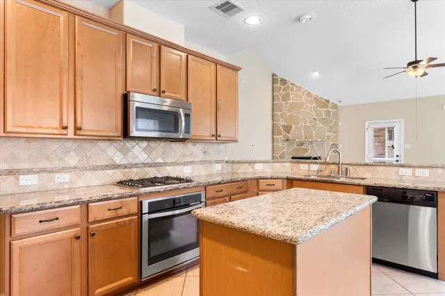 a kitchen with stainless steel appliances granite countertop a sink stove and microwave