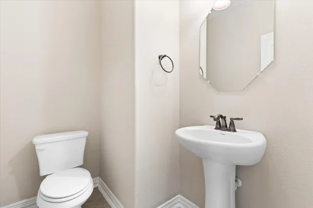 a bathroom with a sink a toilet and mirror