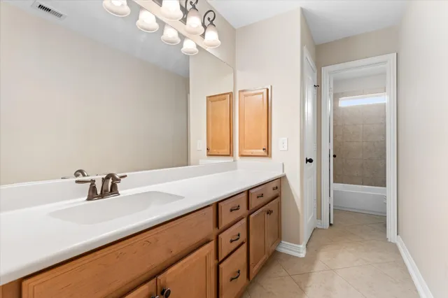 a bathroom with a sink a light fixture and a mirror