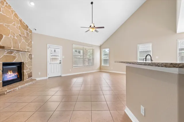 a view of an empty room with a fireplace and a window