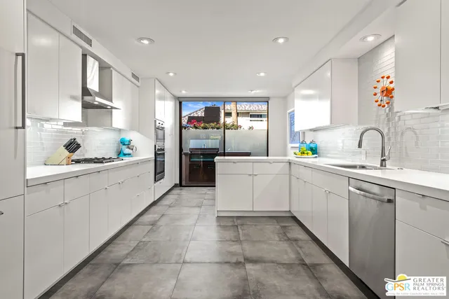 a kitchen with stainless steel appliances granite countertop a refrigerator and a view of living room