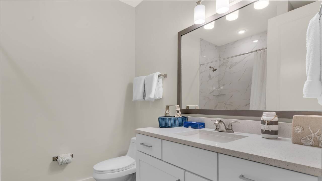 179 South County Highway 393, Unit 333 Santa Rosa Beach, FL 32459 - Photo 13 of 34 a bathroom with a granite countertop sink mirror vanity and toilet