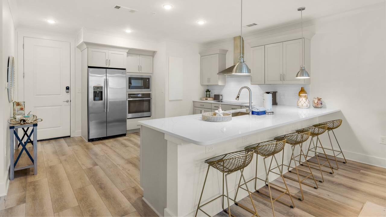 179 South County Highway 393, Unit 333 Santa Rosa Beach, FL 32459 - Photo 5 of 34 a kitchen with stainless steel appliances kitchen island granite countertop a kitchen island hardwood floor and a sink
