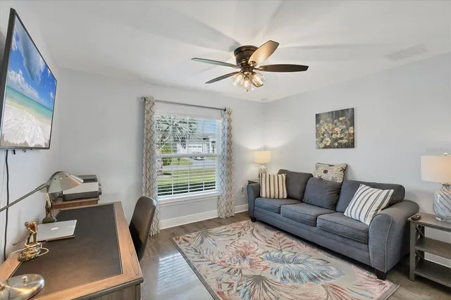 a living room with patio furniture and a potted plants