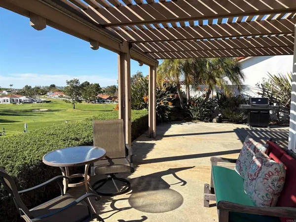 a view of a chairs and table in patio with a barbeque