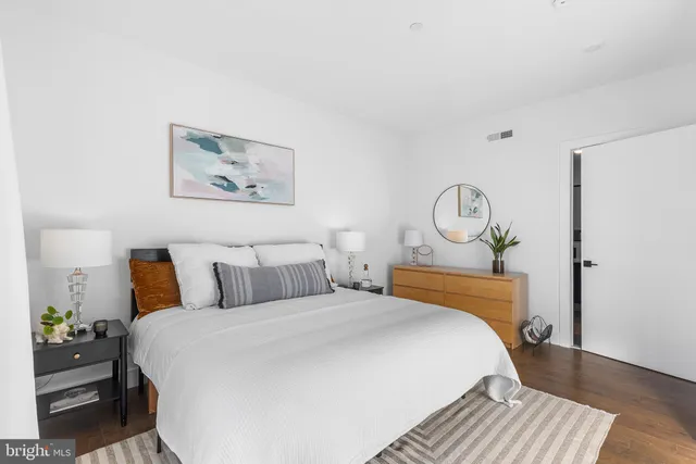 a bedroom with a bed and wooden floor