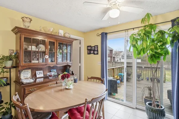 a dining room with furniture a floor to ceiling window and potted plants