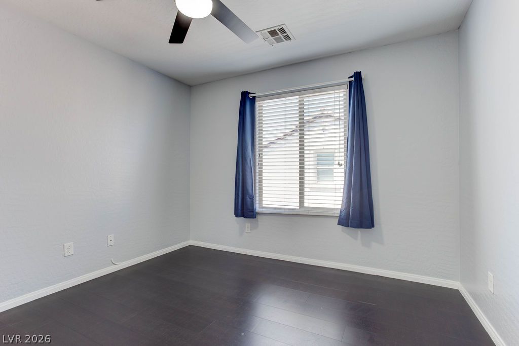 7724 Vibrant Thread Court Las Vegas, NV 89149 - Photo 30 of 43 A well-lit bedroom features durable laminate flooring and a ceiling fan for comfort.