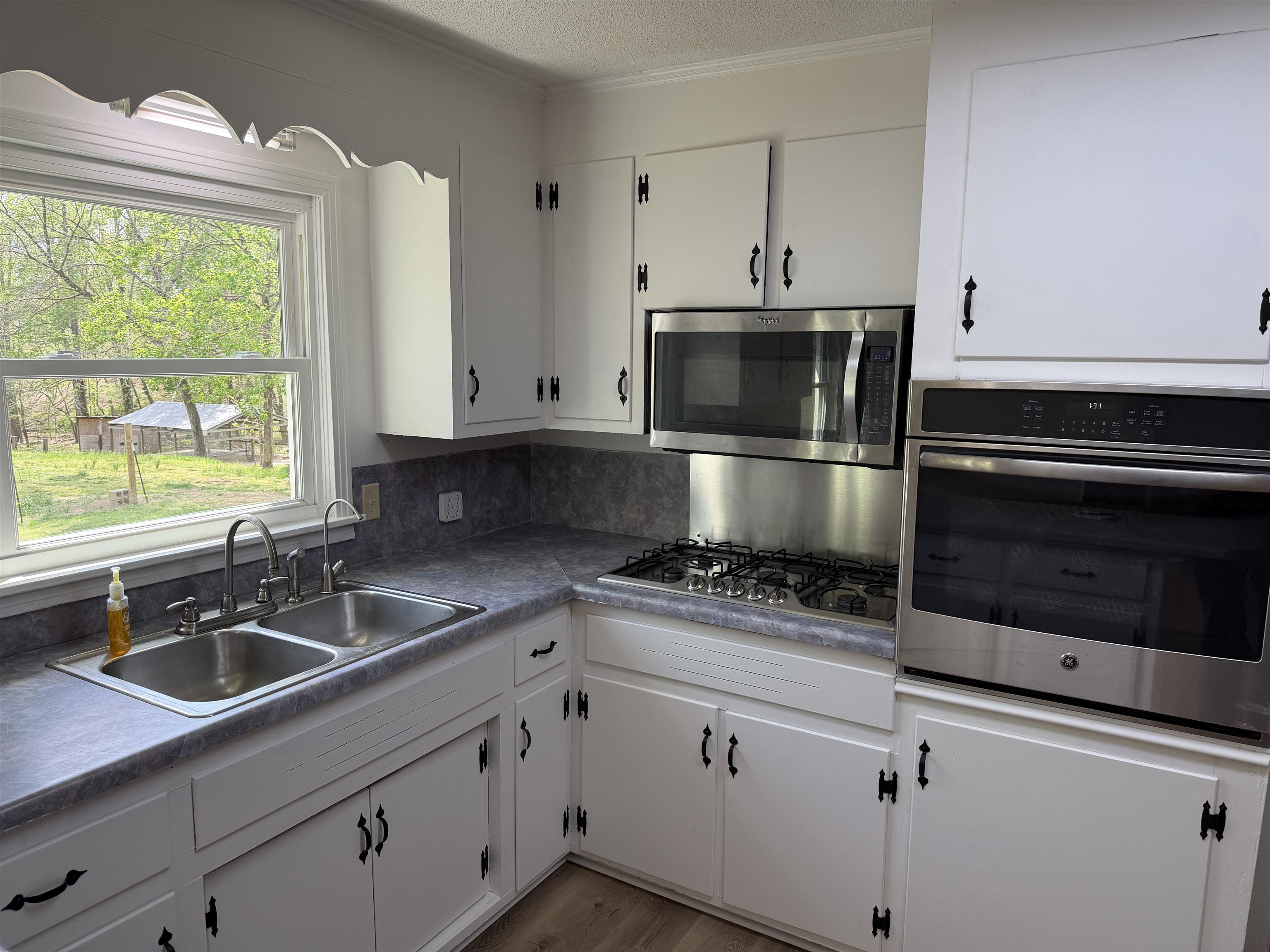 940 Old Lula Road Reagan, TN 38368 - Photo 13 of 39 a kitchen with stainless steel appliances a stove a sink a microwave and cabinets