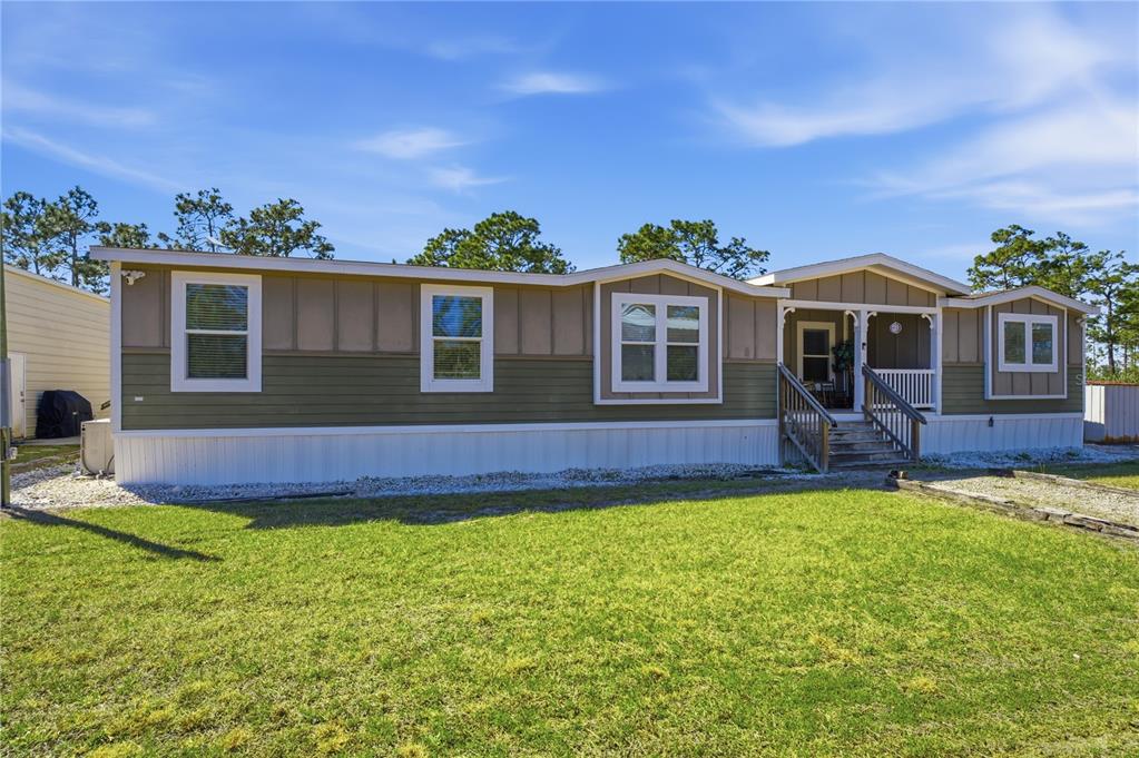 6844 Chad Jason Road St. Cloud, FL 34773 - Photo 1 of 59 a front view of a house with a yard