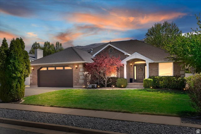 1924 North 2000th Street East Layton, UT 84040 - Photo 1 of 41 View of front of house featuring a yard, a garage, brick siding, driveway, and a chimney