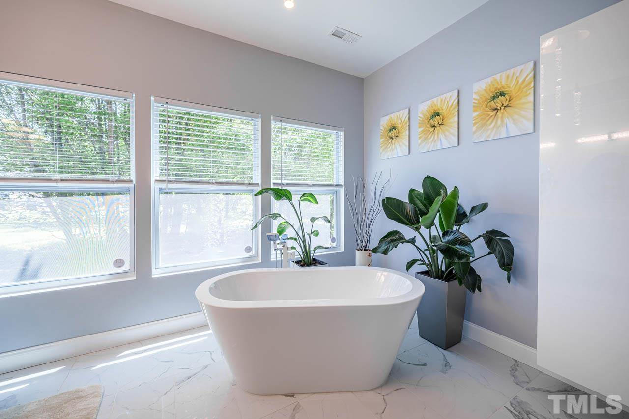 1028 Todd Road Knightdale, NC 27545 - Photo 29 of 48 a white bath tub sitting in a bathroom next to a window