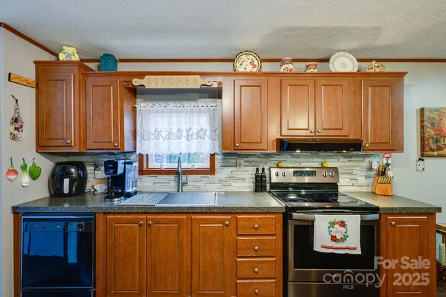 a kitchen with stainless steel appliances granite countertop a stove a sink and a microwave