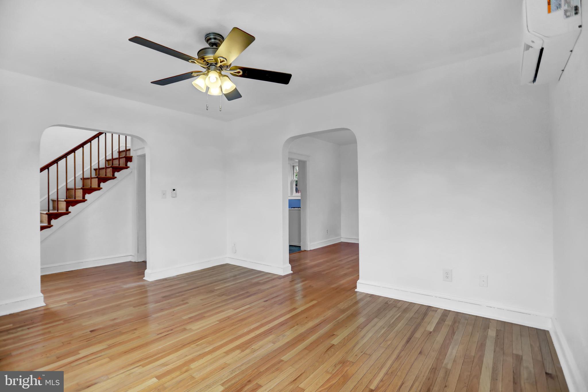 5544 Ashbourne Road Baltimore, MD 21227 - Photo 17 of 40 a view of an empty room with wooden floor and a ceiling fan