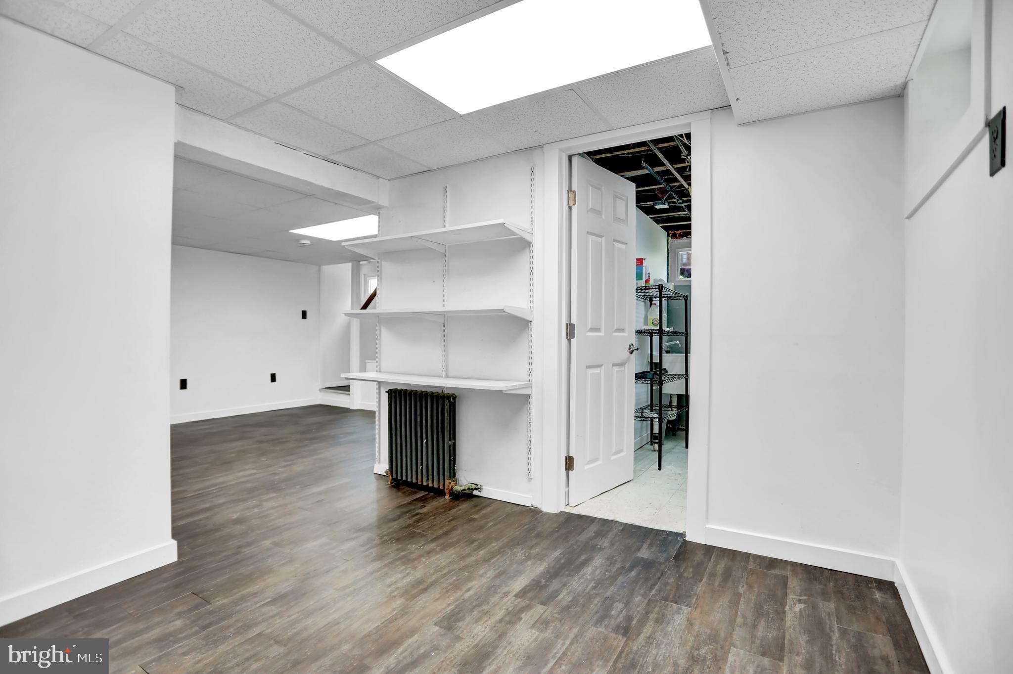 5544 Ashbourne Road Baltimore, MD 21227 - Photo 18 of 40 a view of empty room with wooden floor and fireplace