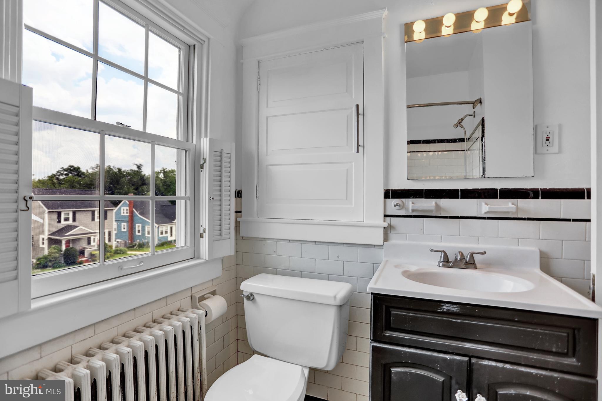 5544 Ashbourne Road Baltimore, MD 21227 - Photo 2 of 40 a bathroom with a sink a toilet and a window