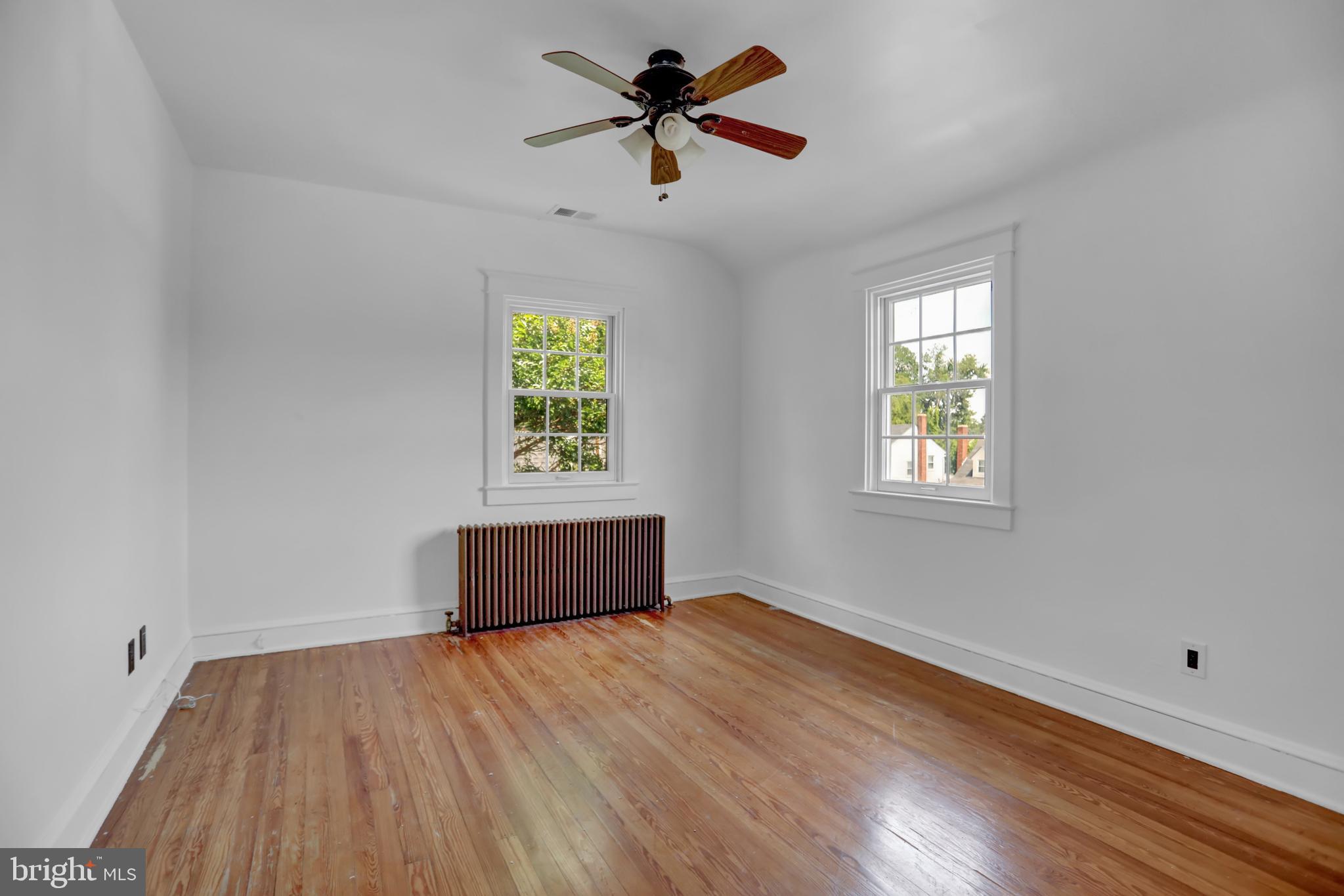 5544 Ashbourne Road Baltimore, MD 21227 - Photo 21 of 40 an empty room with windows and a ceiling fan