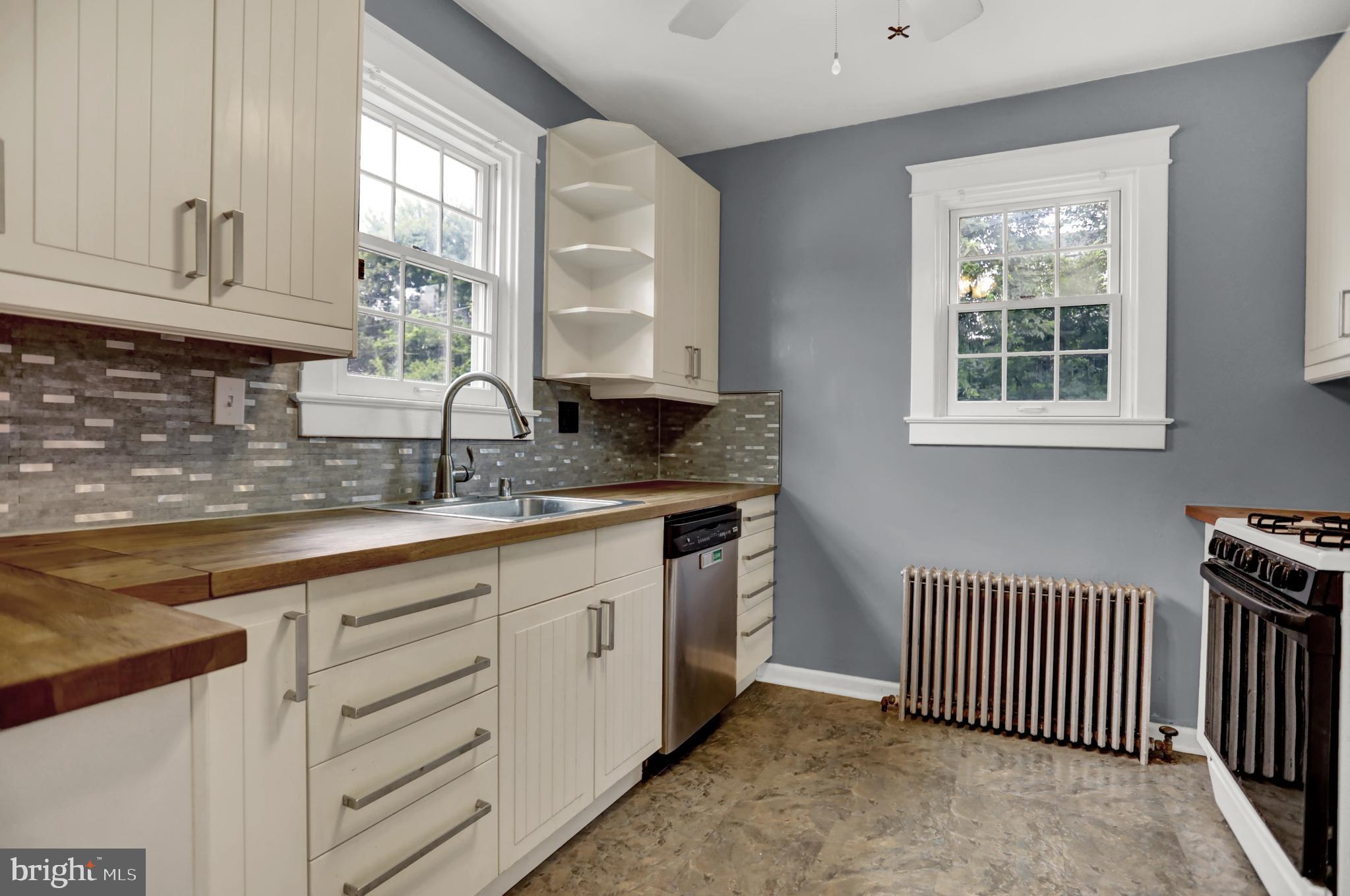 5544 Ashbourne Road Baltimore, MD 21227 - Photo 38 of 40 a kitchen with granite countertop a sink window and cabinets