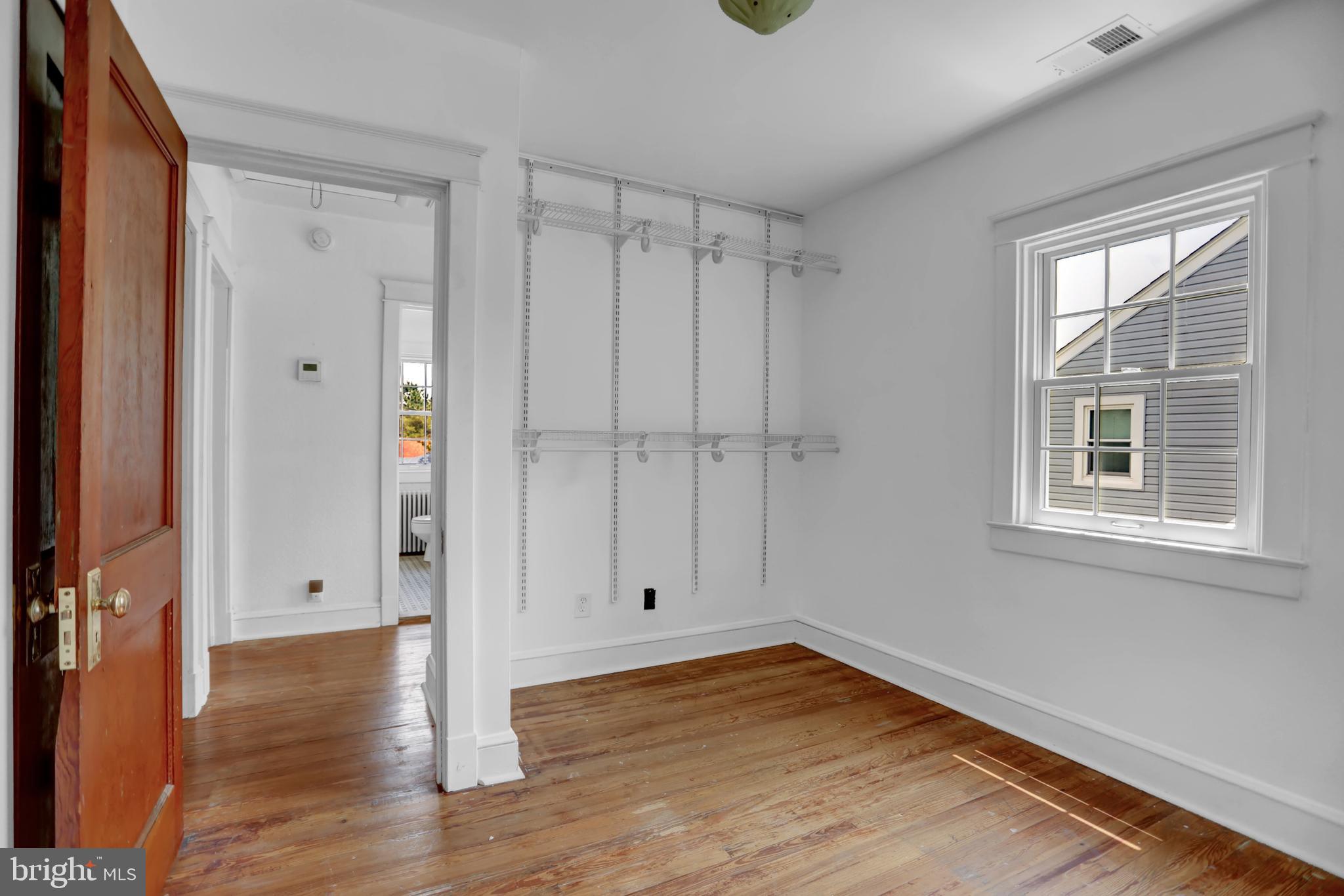 5544 Ashbourne Road Baltimore, MD 21227 - Photo 40 of 40 a view of an empty room with wooden floor and a window