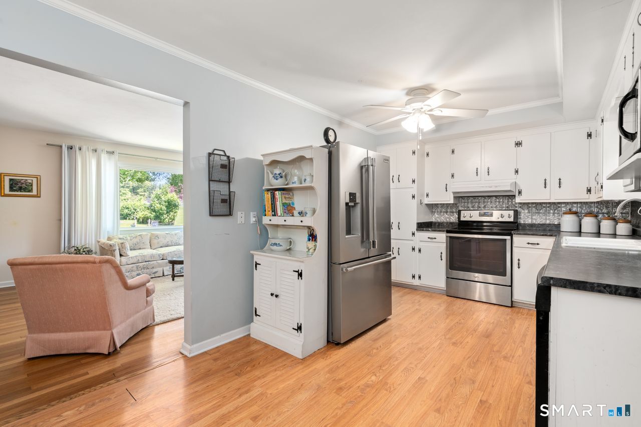 9 Stanton Road North Haven, CT 06473 - Photo 9 of 35 a kitchen with stainless steel appliances a refrigerator a stove a sink a dining table and chairs with wooden floor