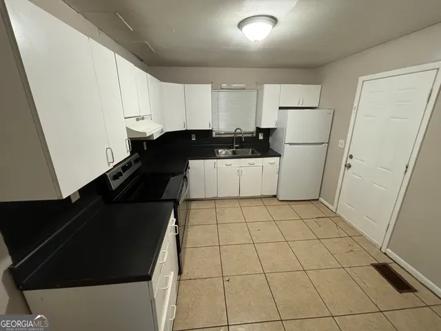 a kitchen with a sink and a refrigerator