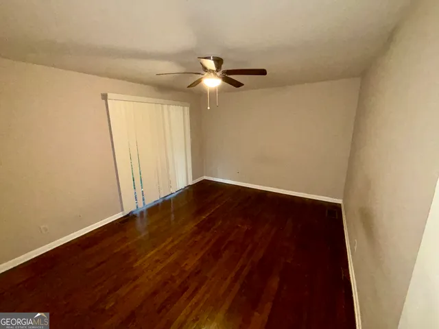 a view of empty room with wooden floor