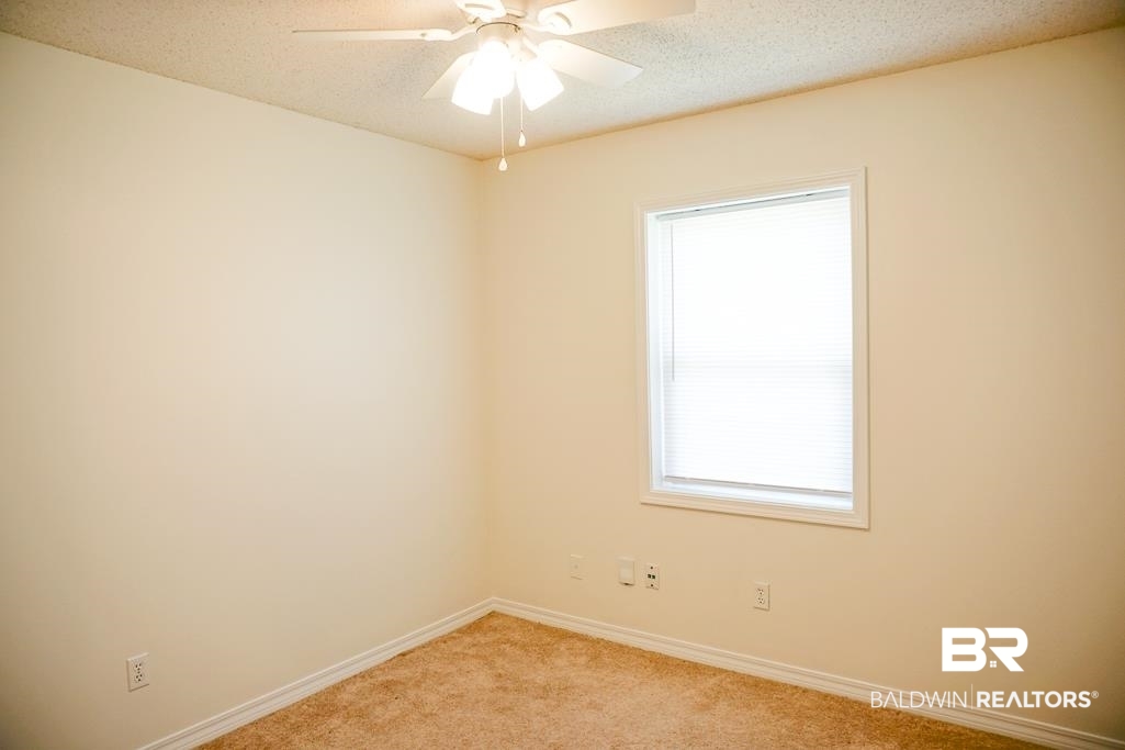 4377 Fathbrook Lane Mobile, AL 36693 - Photo 15 of 19 Empty room with baseboards, light colored carpet, ceiling fan, and a textured ceiling