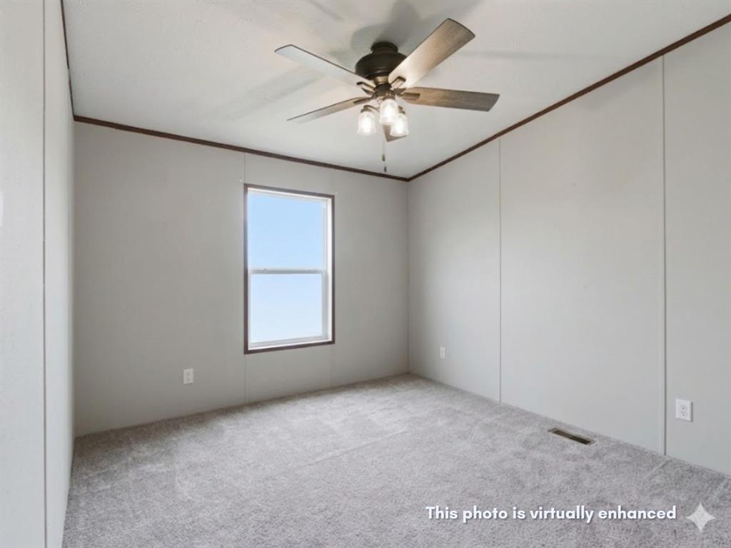 2722 Denver Road Sunset, TX 76270 - Photo 10 of 19 Room featuring light gray wall paneling, gray carpet flooring, and a single window with dark trim