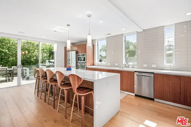 a dining hall with stainless steel appliances granite countertop a stove and a large window