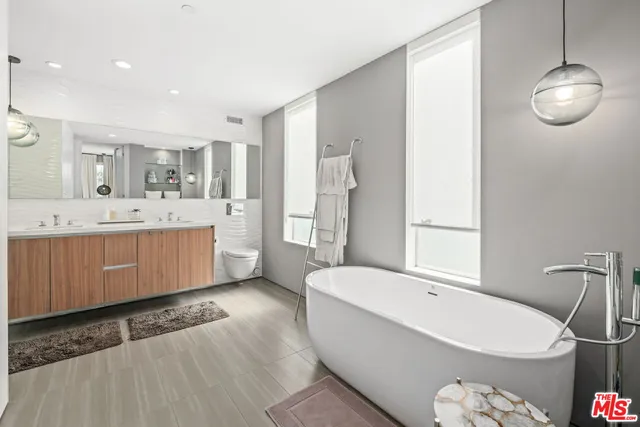 a bathroom with a sink a toilet a mirror and shower