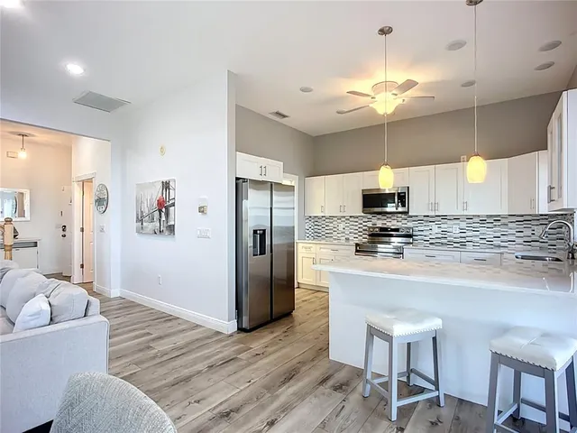 a kitchen with kitchen island a counter top space a sink stainless steel appliances and cabinets
