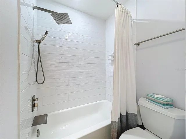 a bathroom with a toilet and a bath tub
