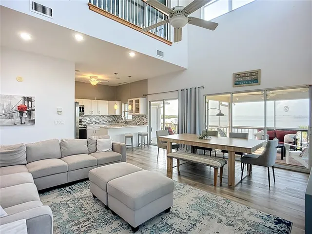 a living room with furniture wooden floor and a large window